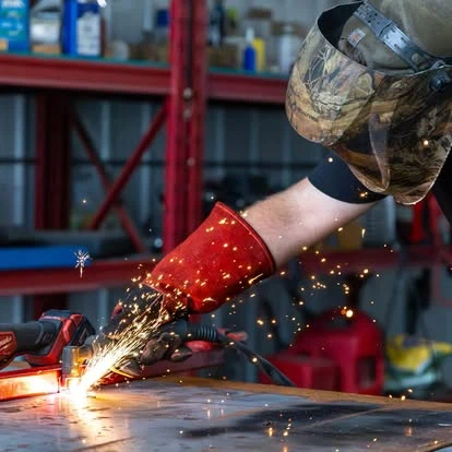 A Newport technician working with metal, with sparks at the workbench