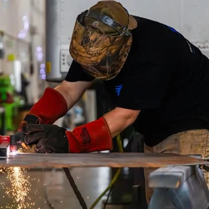 A Newport team member working with metal at a shop bench