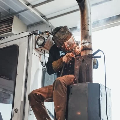 A Newport technician welding on a truck in the shop